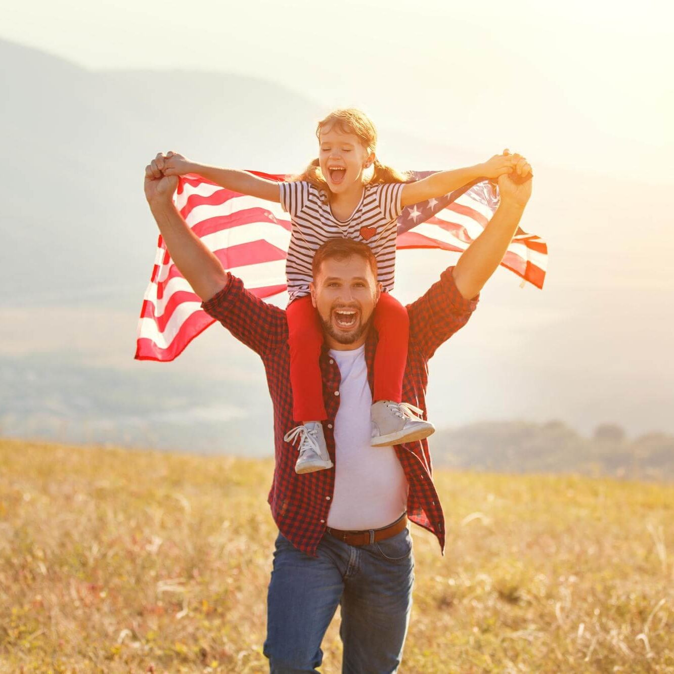 happy-family-father-child-with-flag-united-states-enjoying-sunset-nature (1)